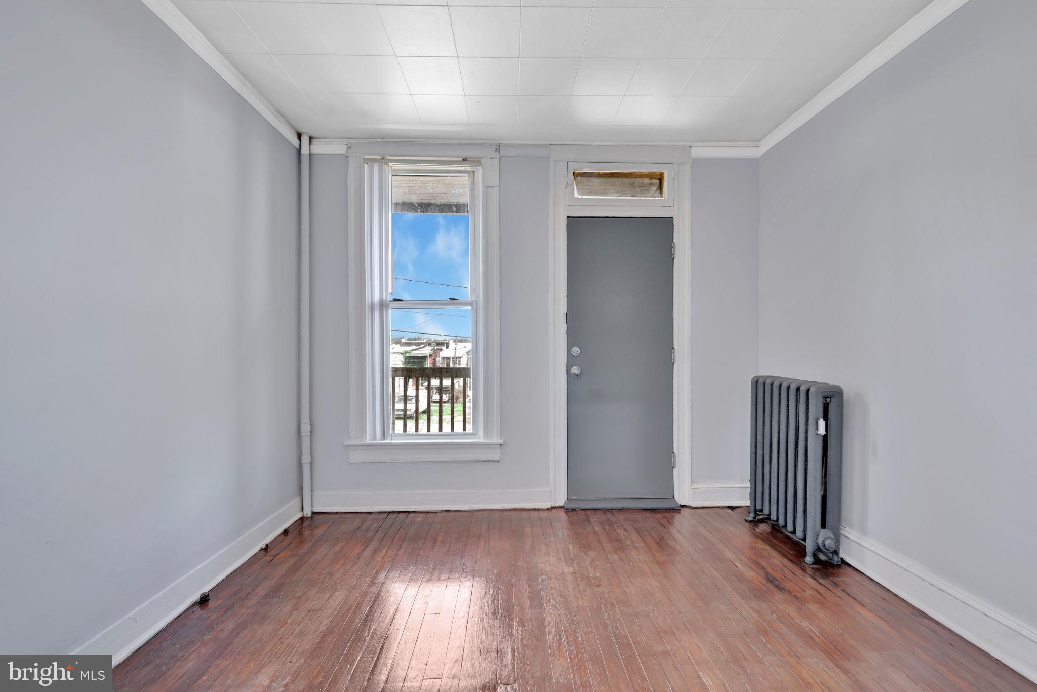 2822 Riggs Avenue Baltimore, MD 21216 - Photo 2 of 30 an empty room with wooden floor and windows