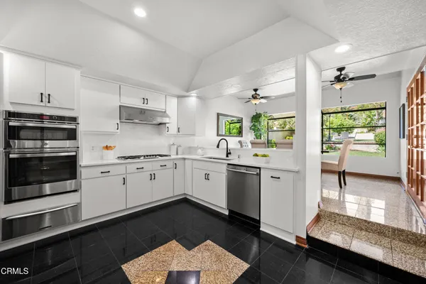 a bathroom with a granite countertop sink a toilet and shower