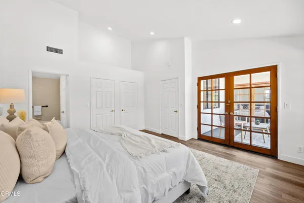 a view of a hallway with wooden floor and a bathroom