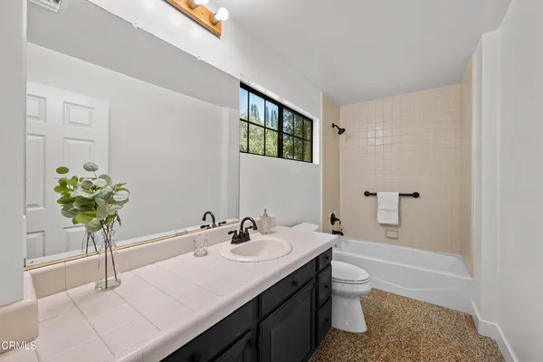 a bed sitting in a spacious bedroom next to a window