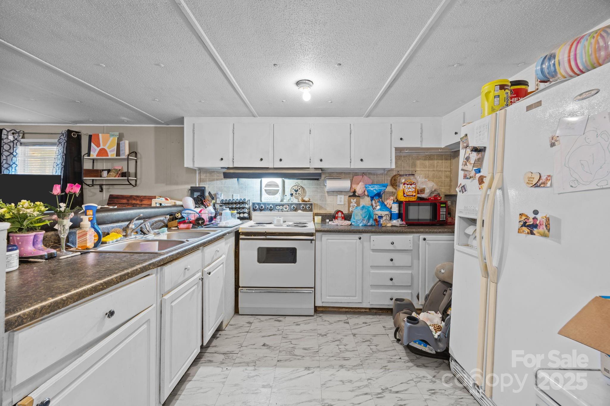 3178 Foxford Road Concord, NC 28025 - Photo 30 of 48 a kitchen with white cabinets and white appliances