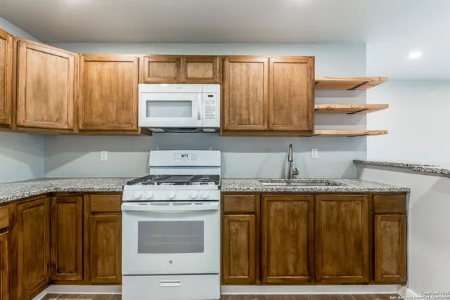 a kitchen with granite countertop cabinets stainless steel appliances and sink
