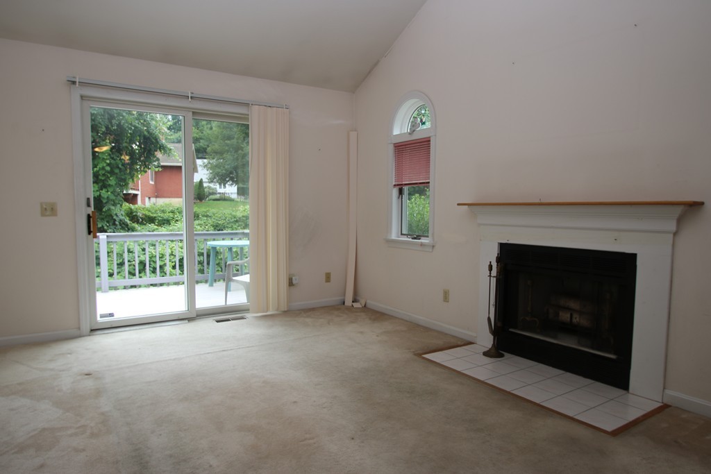 1 Lamplighters Way Saugus, MA 01906 - Photo 9 of 19 a view of an empty room with a fireplace and a window