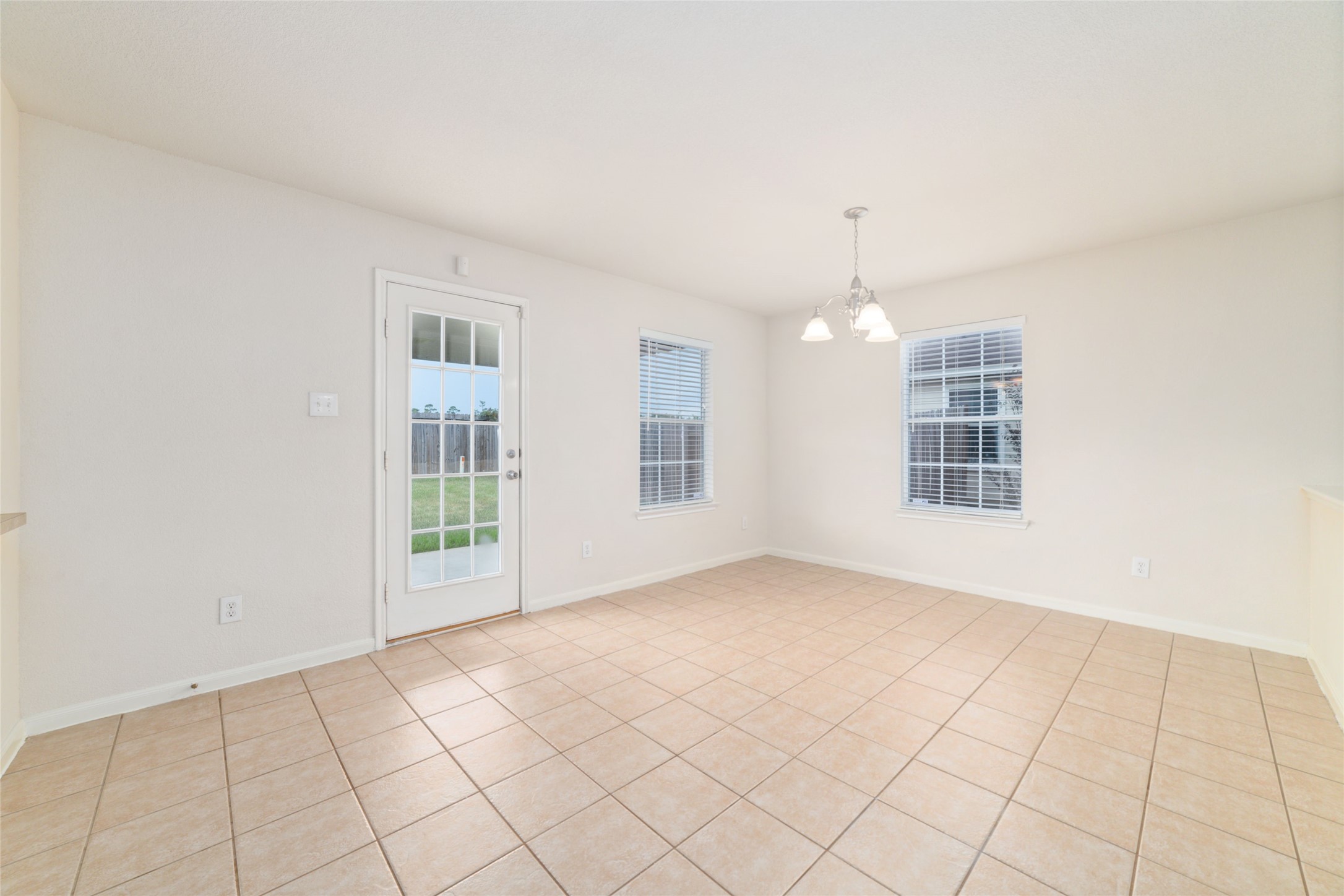 21311 Shadow River Lane Spring, TX 77379 - Photo 18 of 38 an empty room with windows and chandelier
