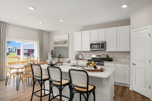a kitchen with stainless steel appliances granite countertop a table and chairs in it