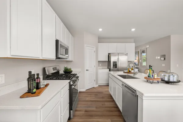 a kitchen with stainless steel appliances granite countertop a sink stove and cabinets