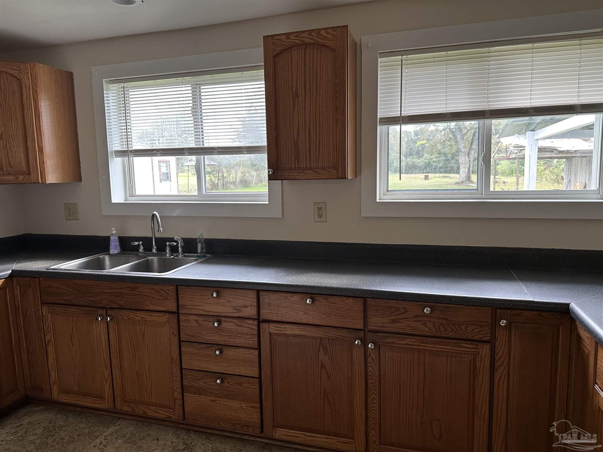 1052 Well Line Road Cantonment, FL 32533 - Photo 13 of 18 a kitchen with sink window and cabinets