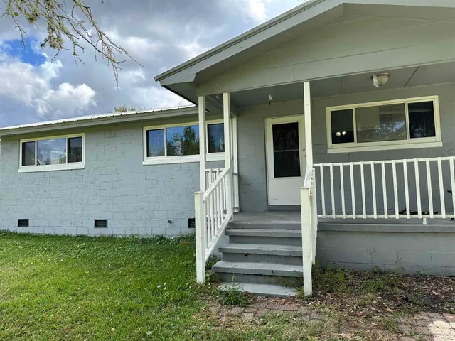 a view of a house with backyard and wooden fence
