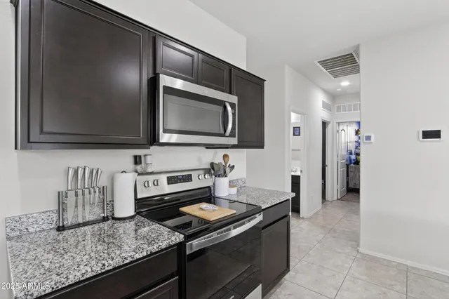 a kitchen with stainless steel appliances granite countertop a refrigerator stove and microwave