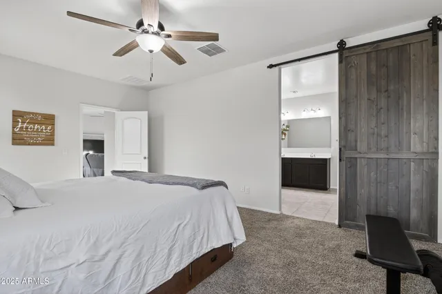 a bedroom with a large bed and a chandelier