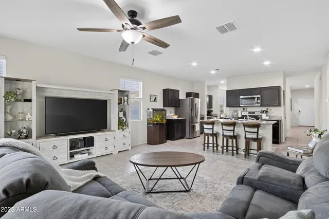 a living room with furniture kitchen view and a flat screen tv