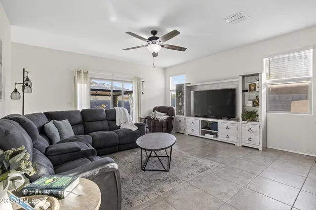 a living room with furniture a flat screen tv and a window
