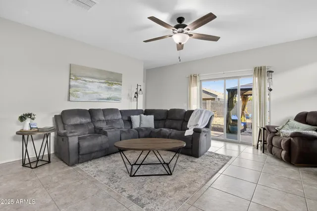 a living room with furniture kitchen view and a large window