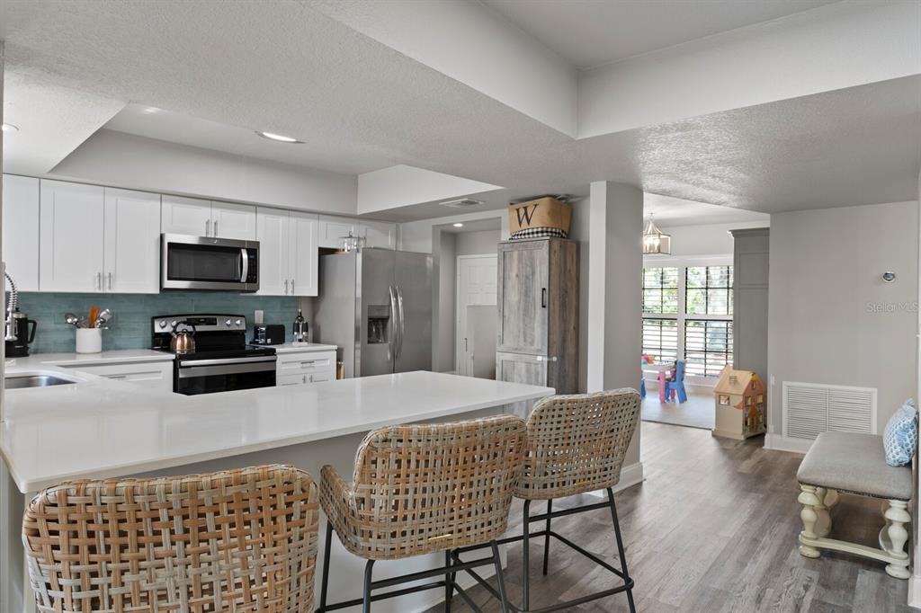 6712 Jennifer Drive Temple Terrace, FL 33617 - Photo 2 of 30 a kitchen with stainless steel appliances kitchen island granite countertop a refrigerator a stove a sink dishwasher with a dining table and chairs