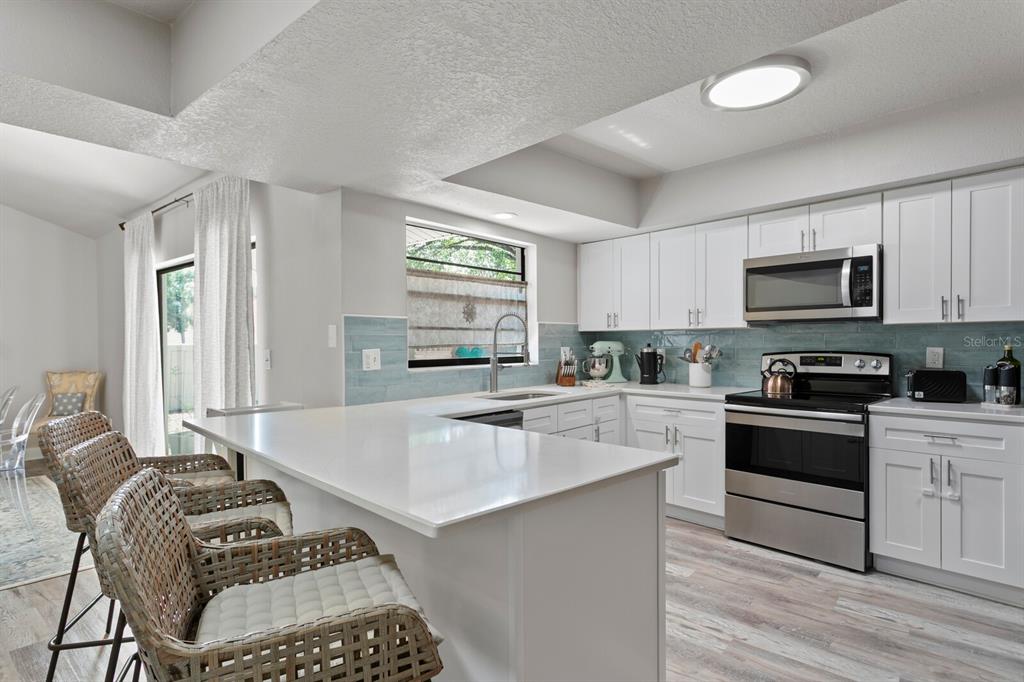 6712 Jennifer Drive Temple Terrace, FL 33617 - Photo 4 of 30 a kitchen with a sink stove top oven and microwave