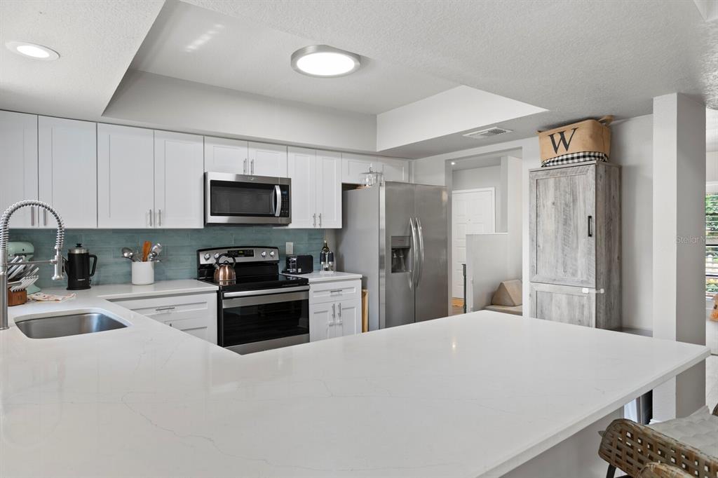 6712 Jennifer Drive Temple Terrace, FL 33617 - Photo 9 of 30 a kitchen with stainless steel appliances a refrigerator stove microwave and sink
