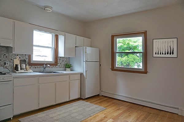 150 Brown Street, Unit 1L Waltham, MA 02453 - Photo 2 of 11 a kitchen with a refrigerator and window