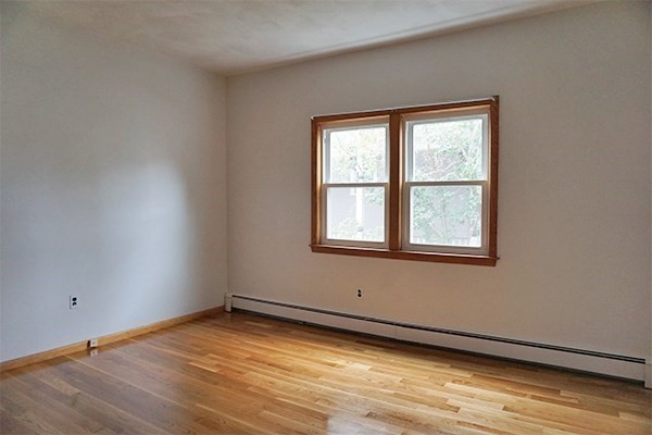 150 Brown Street, Unit 1L Waltham, MA 02453 - Photo 5 of 11 a view of an empty room with wooden floor and a window
