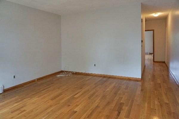 150 Brown Street, Unit 1L Waltham, MA 02453 - Photo 9 of 11 a view of empty room with wooden floor