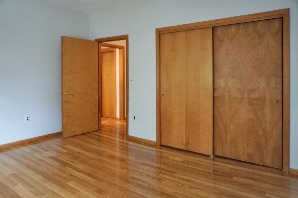 150 Brown Street, Unit 1L Waltham, MA 02453 - Photo 10 of 11 a view of an empty room with wooden floor and a window
