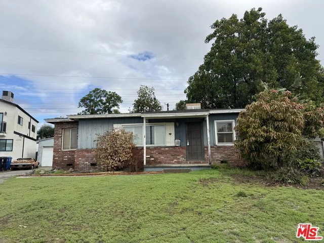 a front view of house with yard and trees in the background