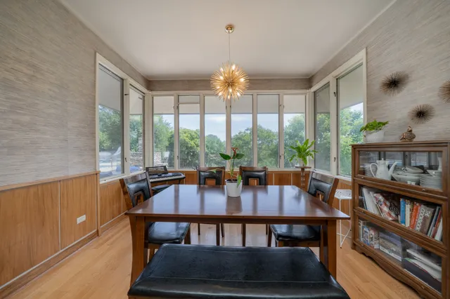 a view of a dining room with furniture large windows and wooden floor