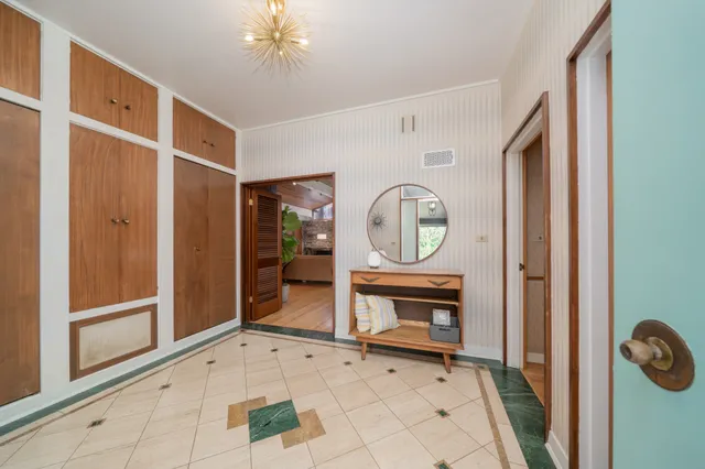 a view of an entryway with wooden floor and a fireplace