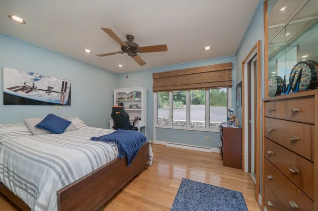 a spacious bedroom with a large bed and a chandelier fan