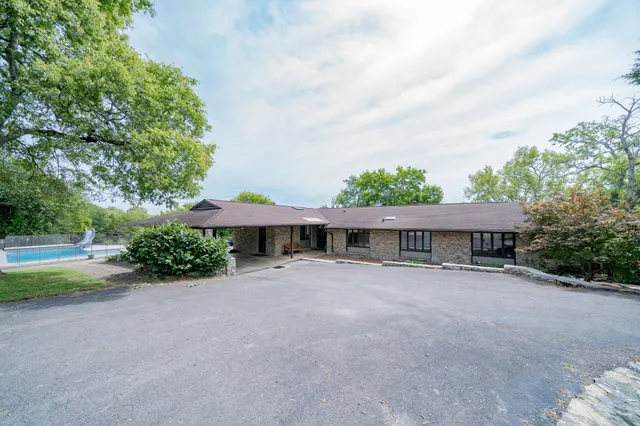 a view of an house with backyard and basketball court