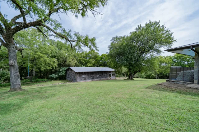 an aerial view of residential houses with outdoor space and trees
