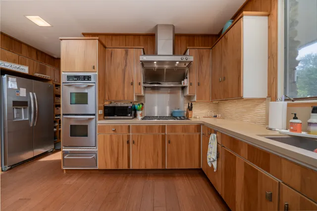 a kitchen with stainless steel appliances a refrigerator and a stove top oven