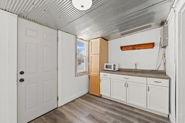 a kitchen with granite countertop white cabinets and sink