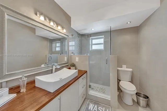 a bathroom with a sink a toilet and a mirror