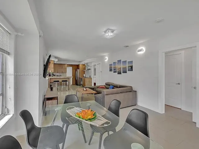 a living room with furniture kitchen view and a window