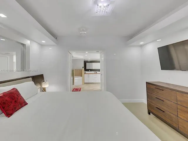 a bedroom with a bed and flat screen tv