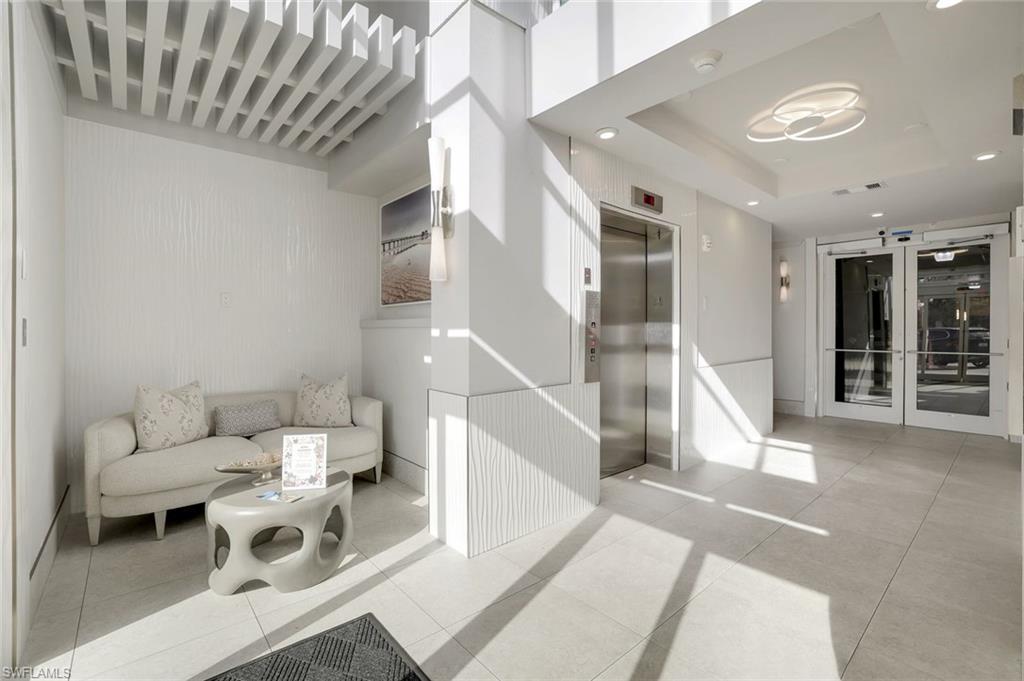 460 Launch Circle, Unit 202 Naples, FL 34108 - Photo 24 of 34 a living room with furniture and a floor to ceiling window