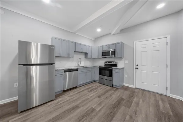 a kitchen with stainless steel appliances granite countertop a refrigerator and a stove top oven