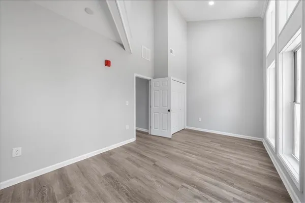 an empty room with wooden floor and window
