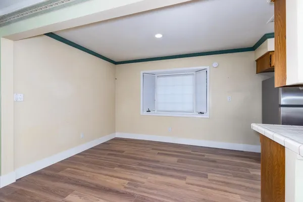 a view of empty room with wooden floor and fireplace