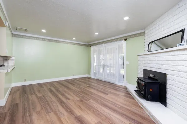 a view of a big room with wooden floor fireplace and windows