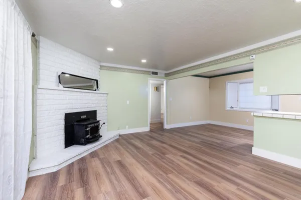a kitchen with stainless steel appliances granite countertop a refrigerator a sink dishwasher and wooden floor