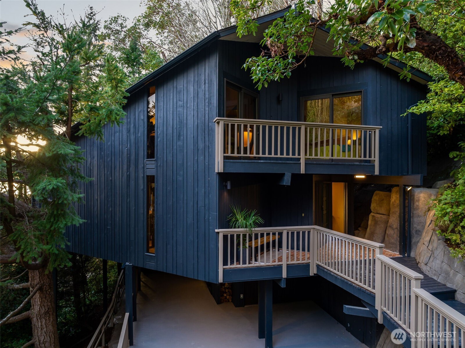 a view of a wooden house with large deck and furniture