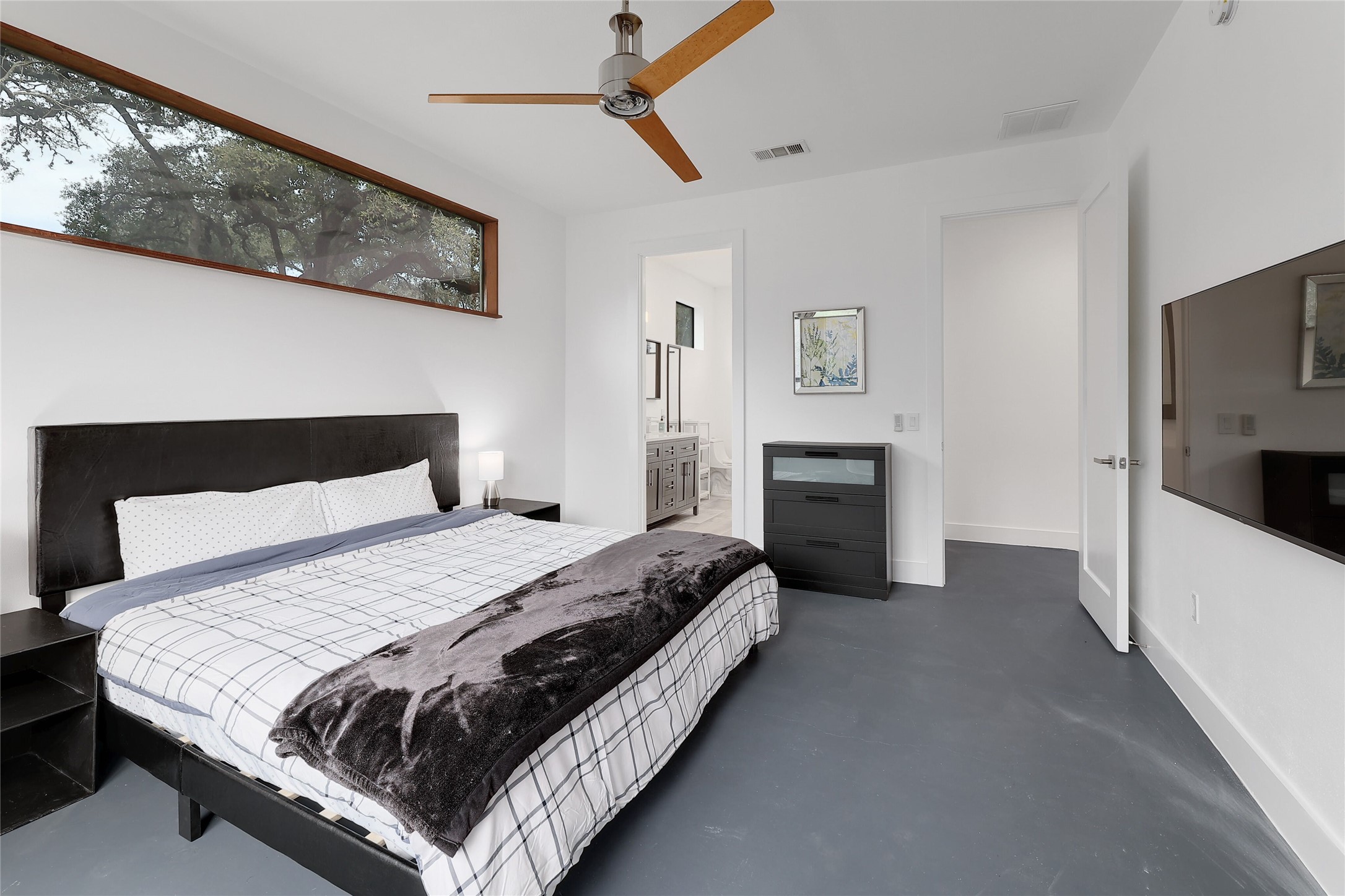 7001 Ranch Road 2222 Austin, TX 78730 - Photo 12 of 18 A tranquil bedroom retreat features high windows offering a serene treetop view.