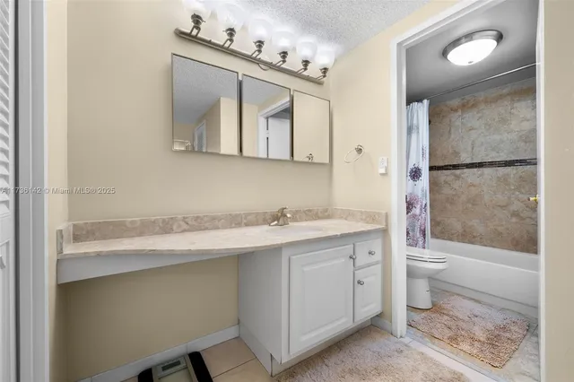 a bathroom with a granite countertop sink a toilet and a mirror