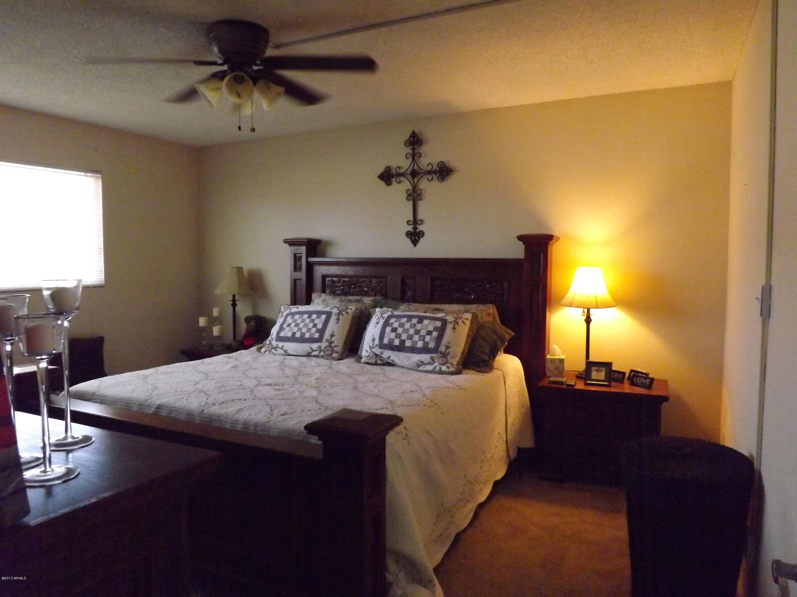 240 Old Litchfield Road, Unit 207 Litchfield Park, AZ 85340 - Photo 4 of 9 a bedroom with a bed and a chandelier