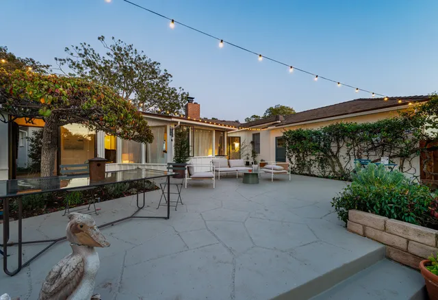 a backyard of a house with table and chairs