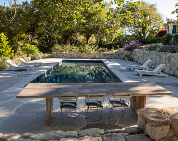 a wooden bench sitting in backside of a house
