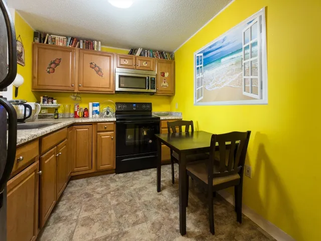 a kitchen with stainless steel appliances a stove a sink dishwasher and wooden cabinets