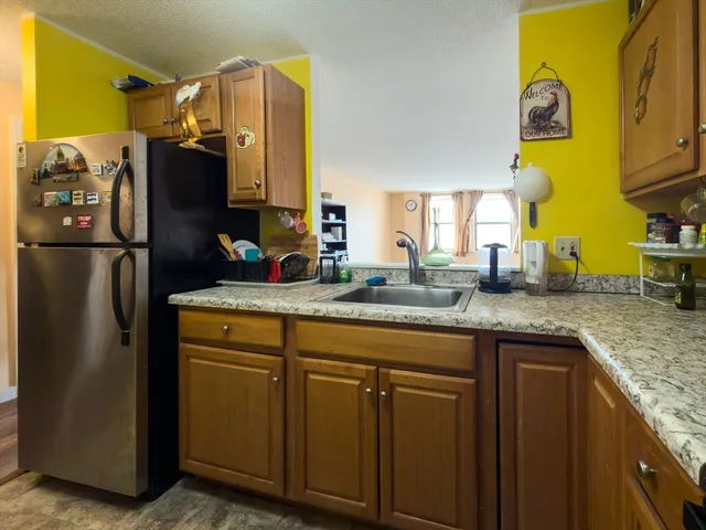 a kitchen with stainless steel appliances granite countertop a refrigerator and a sink