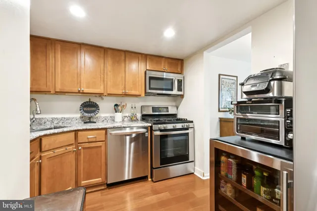 a kitchen with granite countertop a stove top oven microwave and cabinets